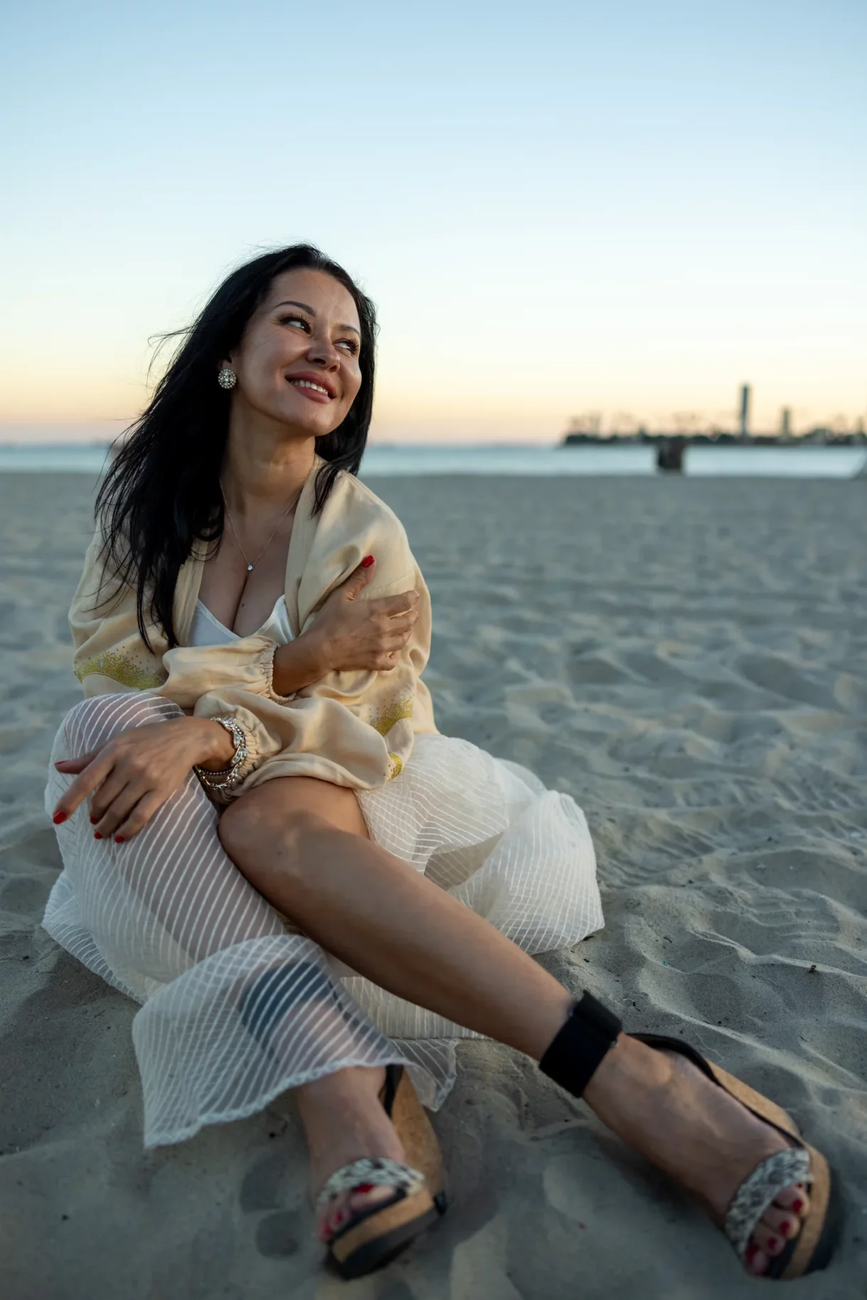 Woman sitting on the beach in a dress during a sunset photoshoot in Long Beach, Los Angeles