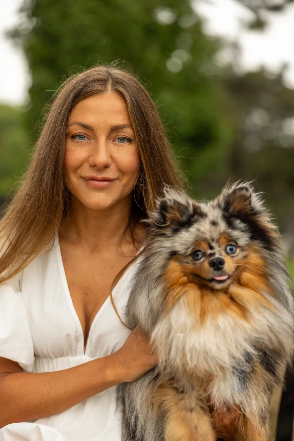 Happy woman with her Pomeranian dog in Beverly Hills greenery