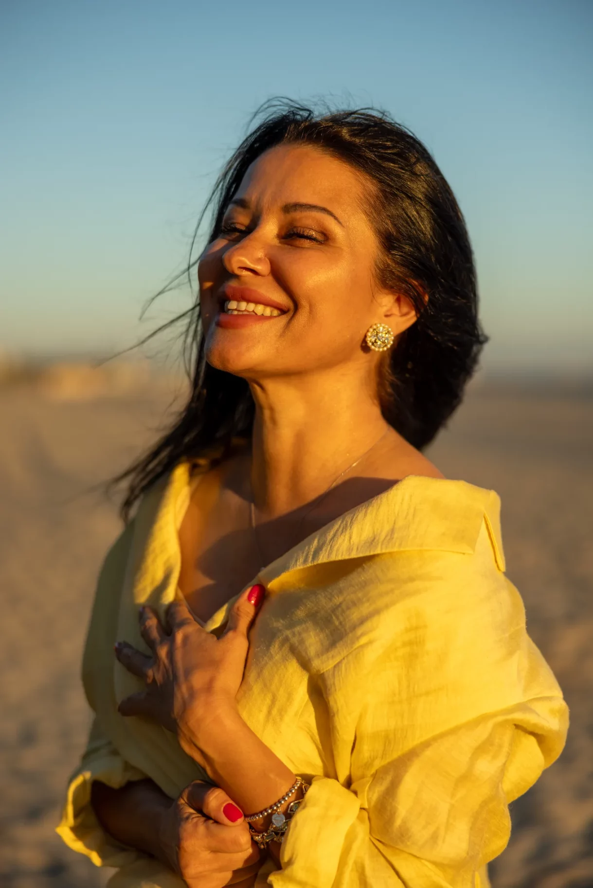 Woman smiling and enjoying the sunset on the beach in Long Beach, Los Angeles