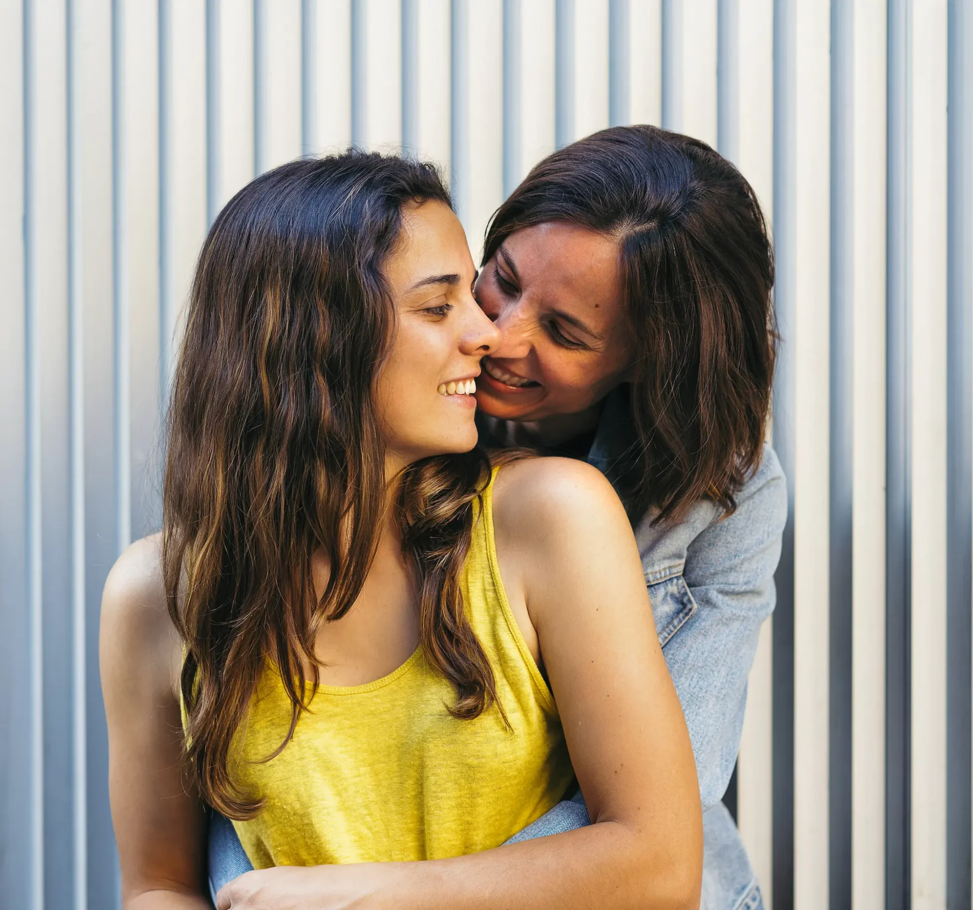 Pareja LGBTQ compartiendo un momento de alegría durante una sesión de fotos en Los Ángeles, que refleja amor y conexión.