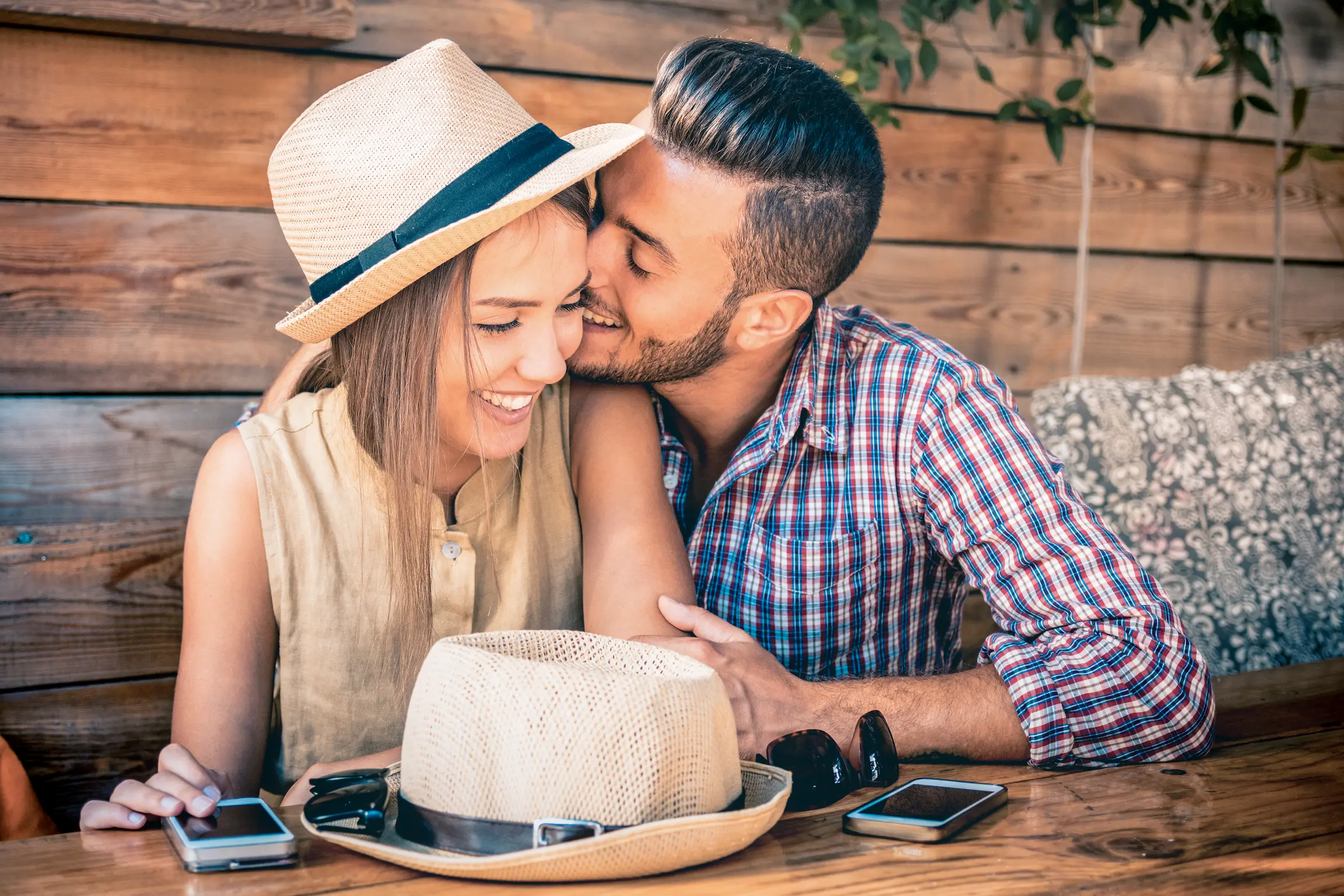 Pareja romántica compartiendo un momento acogedor durante una cita en una cafetería de Los Ángeles.