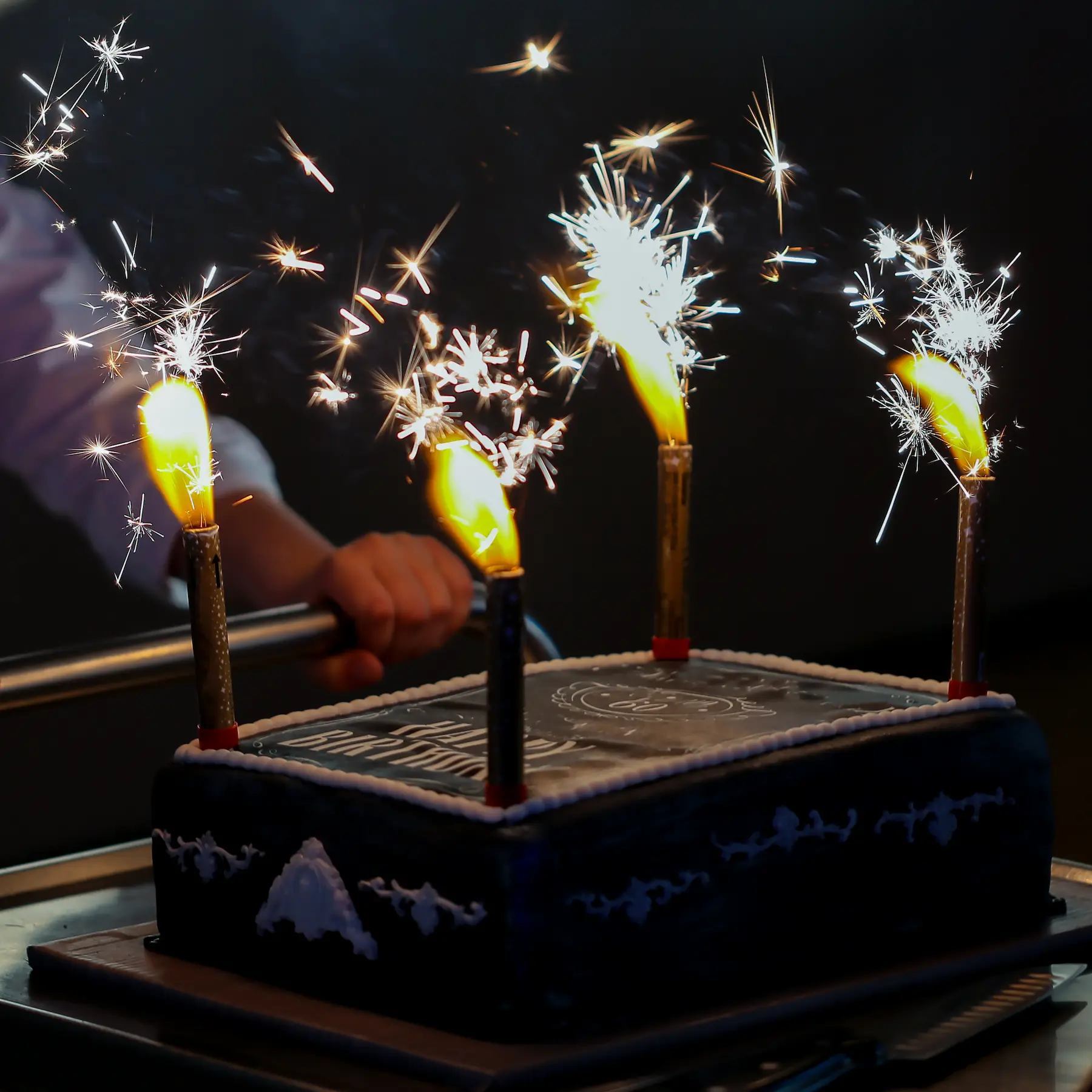 Un pastel de celebración decorado con bengalas durante una fiesta.