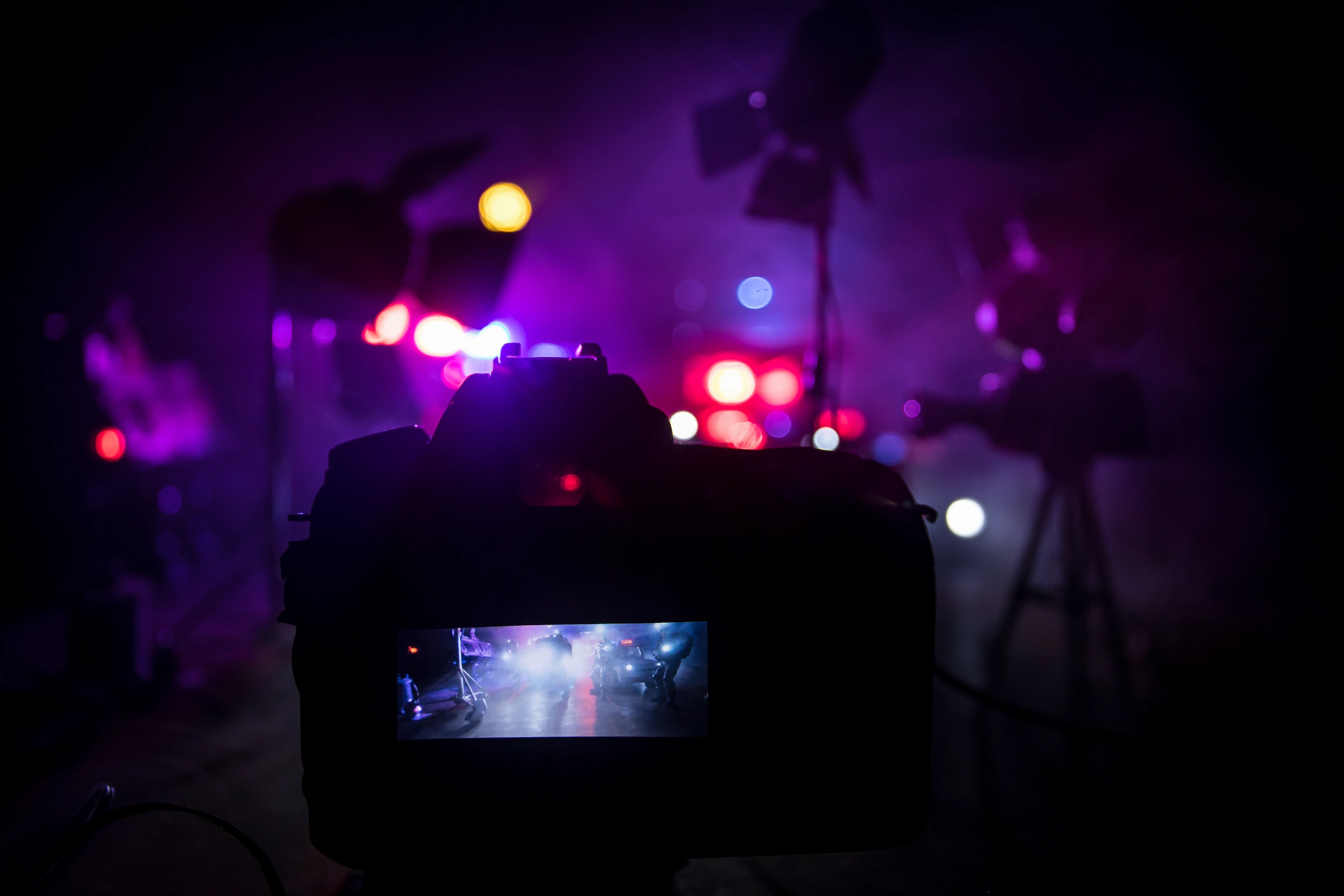 Cámara profesional capturando momentos cinematográficos con iluminación vibrante en un estudio.